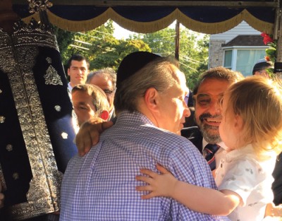 Eric Aminoff dances with the new Torah as it is escorted along Broadway in Lawrence.