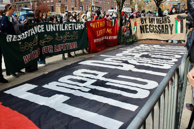Protesters hold anti-Israel, anti-Jewish banners outside of Columbia University's campus after the academic institution suspended its Students for Justice in Palestine chapter, Nov. 15, 2023. Credit: Here Now/Shutterstock.