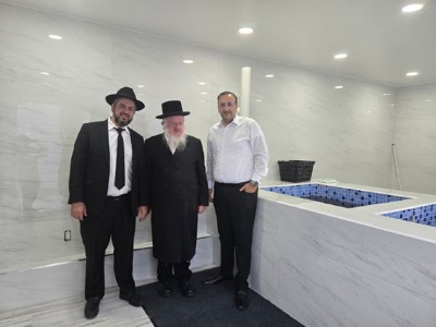 (L-R) Rabbi Nissan Shalomayev, Rabbi Yitzchok Trieger, and Ruben Gurgov pose inside the finished mikvah, marking a moment of celebration for the entire community.