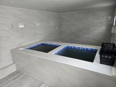The newly completed mikvah features dual immersion pools, tiled in striking blue mosaic and surrounded by polished marble walls, creating a clean and uplifting atmosphere for families fulfilling the mitzvah of tevilat keilim.